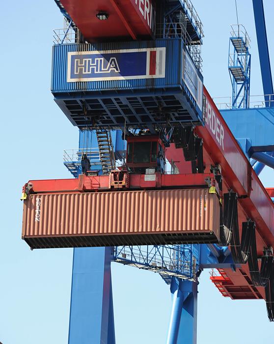 Fotos von der Hafenarbeit im Hamburger Hafen - Containerbrcke. 011_96_2425 Der FEU  (Forty-foot Equivalent Unit) Container wird an dem Laufwagen der Containerbrcke ber die Schiffsladung gehoben und zum Weitertransport abgesetzt.