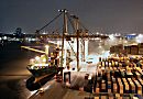 011_15288 ein Containerschiff liegt am Kai des Container Terminals Burchard, auf der anderen Seite der Elbe die beleuchteten Huser von Hamburg Neumhlen. Containercarrier transportieren die Container auf die Lagerflche, auf der die Metallboxen in dichten Reihen  gestapelt sind. Der Hamburger Hafen liegt mit z. Zt. 8.1 Mio TEU weltweit auf Platz acht der Containerhfen. TEU = Container, die 20 Fu Lnge (6,096 m) + die Breite von 8 Fu ( 2,44 m) haben; (Twenty-foot Equivalent Unit) www.fotograf-hamburg.de