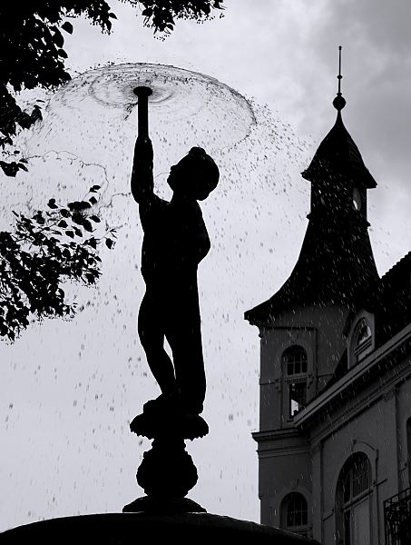 Gegenlicht Fotografie Springbrunnen  Gegenlichtaufnahme von der Putte des Spring- brunnens am Kaiser Wilhelm Platz. Im Hintergrund der Erkerturm eines Grnderzeithauses am Sachsentor.