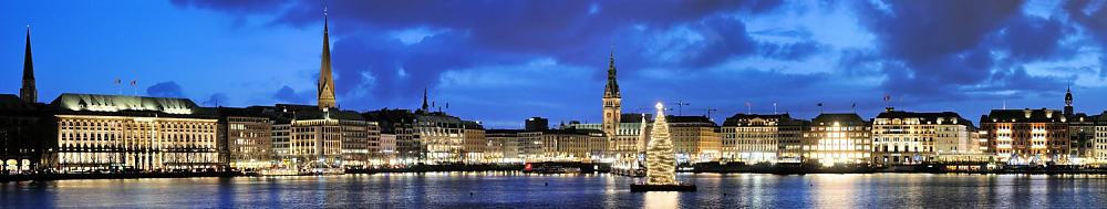 1294-98 Panorama Hamburger Binnenalster zur Blauen Stunde. Blick auf den Jungfernstieg mit den beleuchteten Gesch�ftsh�usern und dem Hamburger Rathaus - links der Turm der Petrikirche + Jacobikirche.�