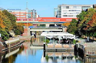 0758 Mittelkanal in Hamburg Hammerbrook - auf einem Ponton ist ein Restaurant eingerichtet - in der S-Bahnstation Hammerbrook fhrt ein Zug ein.