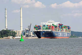 7081 Der Containerfrachter CMA CGM Amerigo Vespucci auf der Elbe vor Wedel - am Ufer die Schornsteine und das Heizkraftwerk Wedel. Die Amerigo Vespucci hat eine Lnge von 365 m und kann 13830 TEU Container transportieren.