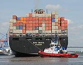 011_57-8029 Das Containerschiff NYK Vesta ist hoch mit Containern beladen - ein Hafenschlepper unterstützt den Frachter bei der Ausfahrt aus dem Hamburer Hafen. Die NYK VETA hat eine Breite von 45,60m und eine Länge von 338m. Mit 8600 TEU voll beladen hat das Frachtschiff einen Tiefgang von 14,50m und kann bei einer Maschinenleistung von ca. 87000 PS 24,5 kn fahren.  ©www.hamburg-fotograf.com