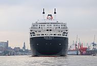 011_61_4694 Am frhen Morgen luft das Kreuzfahrtschiff Queen Mary 2 in den Hamburger Hafen ein - der Name des Schiffs steht auf dem Heck sowie der britische Heimathafen Southamton. Rechts liegt ein roter Container-Feeder im Schwimmdock der Werft Bohm & Voss, lks. die St. Pauli Landungsbrcken und der Kirchturm der St. Michaeliskirche, dem Wahrzeichen Hamburgs.  www.hamburg-fotograf.com 