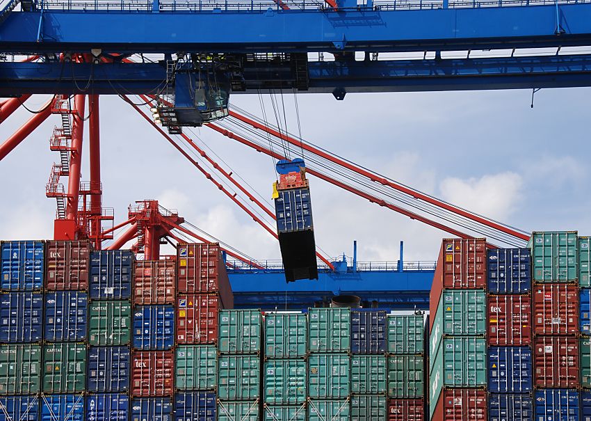 011_15614 die Ladung des Containerschiffs wird entladen; ein Container schwebt an der Containerbrcke und wird an Land gebracht. In der kleinen Kanzel unter der Brcke sitzt der Fhrer der Krananlage und steuert von dort aus seine Arbeit im Hamburger Hafen.  www.fotograf-hamburg.de