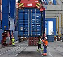 011_15719 Arbeiter in Sicherheitskleidung und mit Helm nehmen am Terminal Burchardkai einen Container in Empfang, der von der gerade Containerbrücke heruntergelassen wird.  ©www.fotograf-hamburg.de 