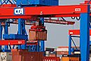 011_15652 der Container hngt an einem fahrbaren Kran und wird auf dem Lagergelnde gestapelt. Im Hintergrund die Containerbrcken mit dem Schriftzug CONTAINER TERMINAL ALTENWERDER CTA.www.fotograf-hamburg.de