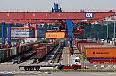 011_15671 Blick auf den Gterbahnhof vom Container Terminal Altenwerder; im Vordergrund ein leerer Lastzug; grosse Bahnkrne berspannen die Bahngleise und beladen die einzelnen Waggons mit ihrer Containerfracht. Der Bahnkran transportiert den Container vom Transportchassis zum Gterzug. www.fotograf-hamburg.de