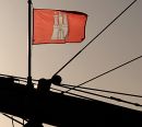 011_32755/00 Bugspriet des Hamburger Museumsschiffs Rickmer Rickmers in der Abendsonne - die Hamburg Flagge / Fahne weht im Wind.  Der historische Grosssegler liegt an den St. Pauli Landungsbrücken und wurde 1896 gebaut .  ©www.fotograf-hamburg.de