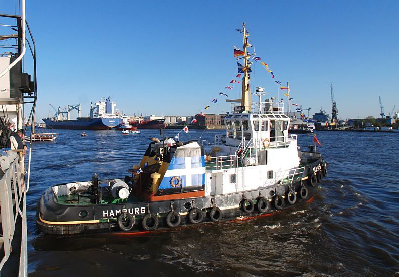 011_26033  Fotos von Hamburg / Bilder vom Hafenpanorama // Der 1740 PS starke Schlepper Hans bei seiner Arbeit im Hamburger Hafen auf der Elbe - am Heck hat er den Schriftzug "Hamburg" stehen und auf der ganzen Schiffsseite sind Gummireifen als Fender ausgehngt, die das Bugsieren der anderen Schiffe vor Stssen schtzen soll. Auch das Heck ist mit starkem Gummi versehen, damit das Hamburger Arbeitsboot damit z. B. ein Schiff vorsichtig an seinen Platz schieben kann.  www.christoph-bellin.de