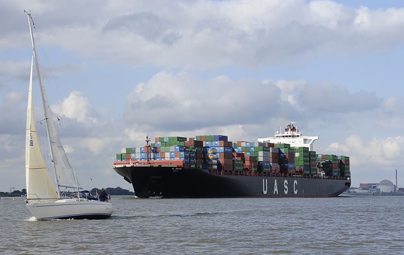 011_26056  Das ca. 300m lange und 40m breite Containerschiff AL BAHIA auf der Elbe - mit knapp 7000 TEU / Containern Fracht hoch beladen fhrt es Richtung Hamburger Hafen. Im Vordergrund ein Segelschiff im Wind.  www.christoph-bellin.de