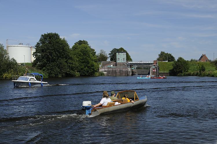 011_26064 Blick zur Krapphofschleuse am Schleusengraben, der zum Bergedorfer Hafen fhrt. Auf der Doveelbe fahren am Sonntag Nachmittag Boot. Beim Anleger an der Schleuse haben einige Kanus fest gemacht, ein kleines Motorboot kommt aus der geffneten Schleuse - ein anderes Sportboot mit Faltdach kommt von der Doveelbeschleuse und ein kleines Boot mit Aussenbordmotor fhrt auf dem ruhigen Wasser der Doveelbe Richtung Curslack.   www.christoph-bellin.de