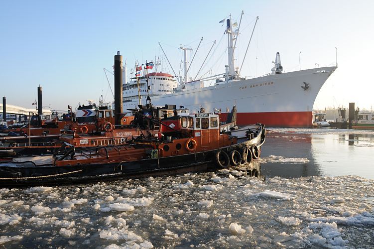 Hamburger Winter - Eis im Hafen, Museumsschiff Cap San Diego - Schlepper am Liegeplatz  011_26075 Schlepper liegen bei den Landungsbrücken; auf dem Wasser des Hafens schwimmen Eisschollen. Das ehemalig Frachtschiff Cap San Diego liegt an der Überseebrücke - es ist seit 1988 Museumsschiff. Seit 2003 steht der 1961 gebaute Stückgutfrachter unter Denkmalschutz. ©www.hamburg-fotograf.com