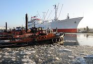 011_26075 Schlepper liegen bei den Landungsbrcken; auf dem Wasser des Hafens schwimmen Eisschollen. Das ehemalig Frachtschiff Cap San Diego liegt an der berseebrcke - es ist seit 1988 Museumsschiff. Seit 2003 steht der 1961 gebaute Stckgutfrachter unter Denkmalschutz. www.hamburg-fotograf.com