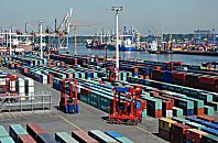 011_15759 Blick ber das Containerlager beim Eurogate Containerterminal zum Waltershofer Hafen - auf der gegenber liegenden Seite das Terminal Burchardkai -  Portalhubwagen fahren auf dem Lagergelnde.die Container sind in Reihen gestapelt - in den Zwischenrumen kann das Transportfahrzeug fahren und den gewnschten Container aufnehmen. 