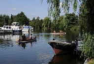 011_26065 zwei Kanus fahren auf der Dove-Elbe in der Nähe von "Auf der Böge"; grosse Motorboote liegen am Ufer des Flusses am Steg, das Tuckerboot HUMMEL hat am Anleger des Hotels Vierlandentor am Curslacker Deich fest gemacht.    ©www.christoph-bellin.de
