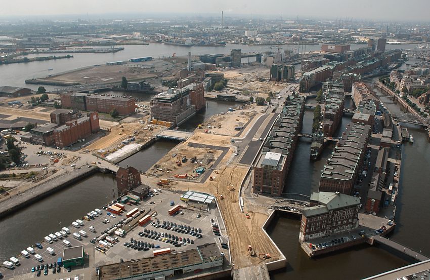 017_18928 Luftaufnahme vom Gesamtareal der Hamburger Speicherstadt und des ehemaligen Freihafengelndes; rechts der Zollkalnal und die Fleete, die durch die Speicherstadt fhren. Auf ihnen wurden die Waren mit Schuten und Transportschiffen an ihren Bestimmungsort gebracht. In der Bildmitte der Kaispeicher A, der zu dem Hamburger Schifffahrtsmuseum umgebaut wurde und im linken Bildbereich der Kaispeicher A, auf dem die sogen. Elbphilharmonie errichtet wird - im linken Vordergrund die Ericusspitze auf dem sich bis Ende 2007 u.a. Stellpltze fr Hamburgtouristen mit Wohnmobil befand. 