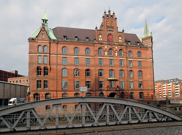 017_18939 Blick ber den genieteten Stahltrger der Neuerwegsbrcke zum Backsteingebude vom Sandtorquai-Hof, der 1888 errichtet wurde - rechts im Hintergrund Wohngebude auf der anderen Seite des Zollkanals "Bei den Neuen Mhren". Die Strasse im Vordergrund hat Kopfsteinpflaster.  www.christoph-bellin.de