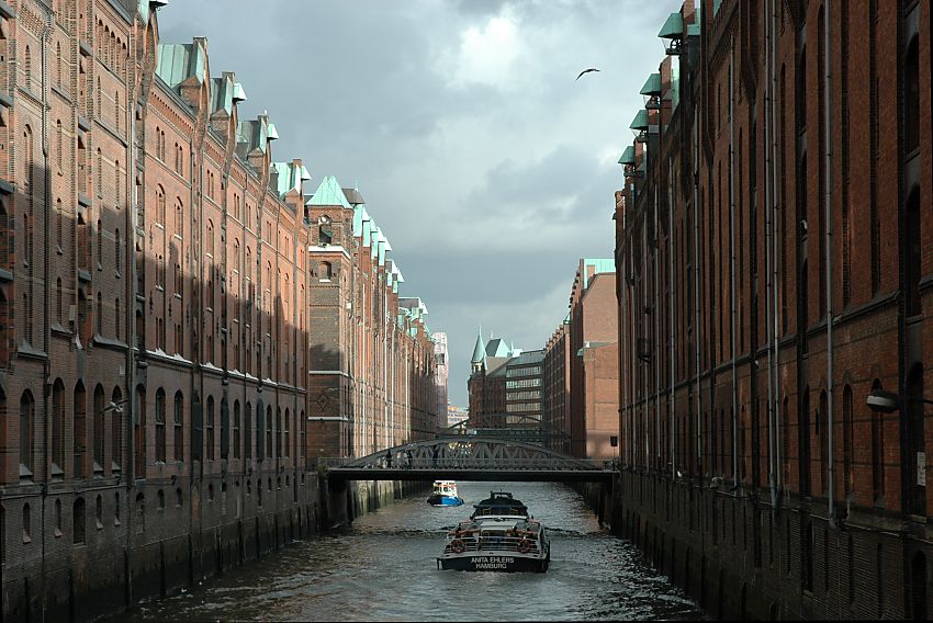 017_18944 Bauf dem Fleet wurden frher die Waren mit einer Schute an die Lagerhuser in der Speicherstadt gebracht - mit den Winden, die ein Kupferdach haben, wurden die Scke und Ballen in ihren Lagerraum / Boden gebracht. Heute fahren Barkassen mit Hamburg Touristen auf den Kanle und die Fremdenfhrer erklren die Geschichte der Speicherstadt.  www.christoph-bellin.de