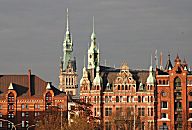 017_18933 Blick zum neogotischen Speicherstadtrathaus in der Abendsonne. In diesem Prunkgebude der Speicherstadt hat die Verwaltung der HHLA, Hamburger Hafen und Logistik AG (vorm. Hamburger Hafen- und Lagerhaus-Aktiengesellschaft) ihren Sitz hat. Links davon der Turm vom Hamburger Rathaus.