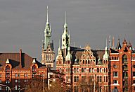 017_18933 Blick zum neogotischen Speicherstadtrathaus in der Abendsonne. In diesem Prunkgebude der Speicherstadt hat die Verwaltung der HHLA, Hamburger Hafen und Logistik AG (vorm. Hamburger Hafen- und Lagerhaus-Aktiengesellschaft) ihren Sitz hat. Links davon der Turm vom Hamburger Rathaus.