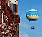 017_18960 an der Fassade vom Lagerhaus in der Hamburger Speicherstadt rankt der Wein; das Laub der Kletterpflanze ist im Herbst röt gefärbt. Im Hintergrund ein Heissluftballon, der mit einem Seil am Boden gehalten wird und den Hamburgern und Hamburg Touristen einen Ausblick auf die Stadt gibt.