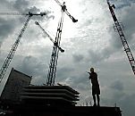 017_18970 Baustelle in der Hafencity am Dalmannkai; Baukrne ragen in den Himmel, ein Baurarbeiter dirigiert einen Baukran, der eine grosse Betronplatte trt mit Sprechfunk zu dem Bestimmungsort.