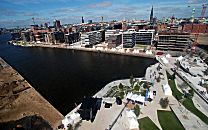 017_18974 Luftaufnahme vom Grasbrookhafen und den Marco-Polo-Terrassen in der Hamburger Hafencity. Im Hintergrund das Panorama Hamburgs und die Kirchtrme der Hansestadt.