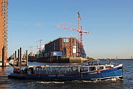 017_18998 eine Barkasse der Hamburger Hafenrundfahrt kommt von den St. Pauli Landungsbrcken / Vorsetzen und fhrt auf die Elbe Richtung Hamburger Hafen. Der Kaispeicher A, die zuknftige Hamburger Elbphilharmonie wurde entkernt. Ein Stahlgerst sttzt die Aussenmauern - hohe Baukrne stehen auf dem Gelnde. Im Hintergrund ist die Hamburger Hafencity am Kaiserkai im Entstehen. 