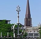 017_19003 Eisenzaun, der die ehem. Zollgrenze am Hamburger Freihafen bildet; ein Dreizack ist als Dekorelement an der Zaunspitze angebracht. Im Hintergrund der Kirchturm der Hamburger Hauptkirche St. Jakobi. www.christoph-bellin.de