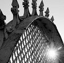 017_19008 die Eisenspitzen des Metallzauns ragen in den Himmel - durch den Maschendraht strahlt die Sonne im Gegenlicht. Hamburger Fotografie ©www.christoph-bellin.de