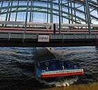 017_19015 Zollgrenze an den Hamburger Elbbrcken. Ein Binnenschiff fhrt in voller Fahrt Richtung Hamburgs Hafen - auf der Brcke fhrt ein Personenzug.  Fotoshamburg :: www.christoph-bellin.de