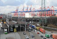 017_19023 Lastwagen, Containertransporter und PKW an der Zollstation Hamburg Waltershof - die LKW stauen sich an der Zollgrenze. Im Hintergrund die Conteinerkrne des Containerterminal am EUROKAI - einige Containerbrcken sind hoch geklappt. die Beladung oder Entladung des Containerschiffs ist abgeschlossen. Rechts ist die Arbeit noch in vollem Gange, die hochgestapelten Container an Deck des Frachters sind gut zu erkennen.    www.christoph-bellin.de