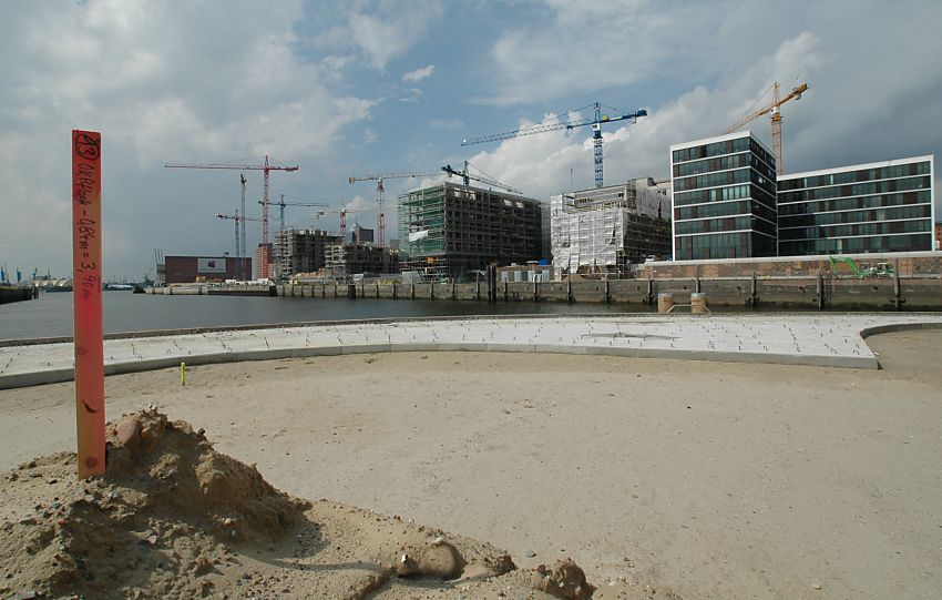 017_18972 die Marco-Polo-Terrassen am Kopfende des Hafenbeckens Grasbrookhafen wird angelegt; die Flche wird mit Sand aufgeschttet, am Kai sind neu gesetzte Duckdalben zu erkennen; rechts die Neubauten/ Wohngebude am Kaiserkai, im Hintergrund der Kaispeicher. Hohe Baukrne arbeiten auf der Baustelle.  www.christoph-bellin.de