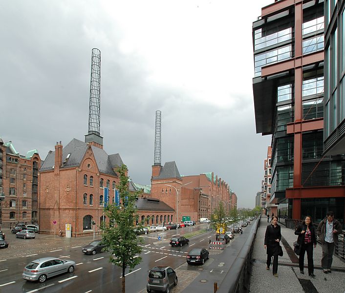 017_18980 Blick in die Strasse Am Sandtorkai in der Hamburger Speicherstadt - rechts die neue Bebauung der Hafencity, die mit der Rckseite am Sandtorhafen steht. In der Bildmitte das ehemalige Kesselhaus, das die Speicherstadt mit Energie versorgte; das historische Gebude steht jetzt unter Denkmalschutz - die Schornsteine wurden durch ein Metallgerst ersetzt. Das Gebude wird als Informationscenter genutzt - ein grosses Modell der zuknftigen Hafencity ist dort aufgebaut.  www.christoph-bellin.de