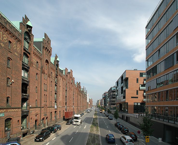 017_18982 links die historischen Speichergebude der Speicherstadt mit den Giebeln, in denen die Winden untergebracht sind; diese transportieren die Waren auf die einzelnen Bden / Lagerrume, die durch Luken zugnglich sind - oben links ist mit helleren Ziegeln die Jahreszahl 1888 eingemauert, das Jahr der Entstehung. Auf der Rechten Seite des Sandtorkais die moderne Architektur der entstehenden Hafencity mit seinen Brohusern und Wohngebuden.  www.christoph-bellin.de