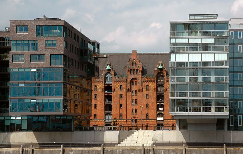 017_18983 lBlick ber den Sandtorhafen zur Bebauung am Sandtorkai - zwischen den neuen modernen Gebuden ist die historische Backsteinarchitektur der Speicherstadt zu erkennen; einzelne Luken der Bden sind geffnet; links und rechts die Kupferdcher der Winden..  www.christoph-bellin.de