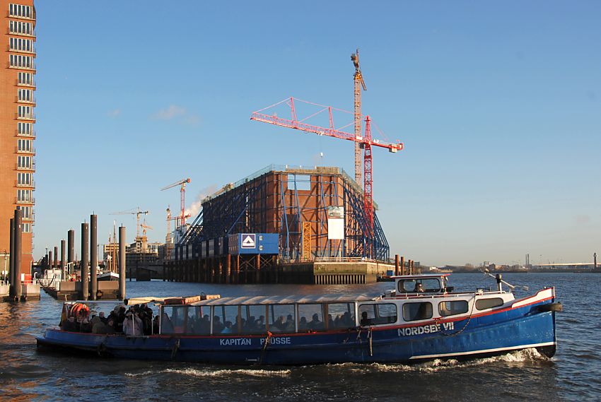 017_18998 eine Barkasse der Hamburger Hafenrundfahrt kommt von den St. Pauli Landungsbrcken / Vorsetzen und fhrt auf die Elbe Richtung Hamburger Hafen. Der Kaispeicher A, die zuknftige Hamburger Elbphilharmonie wurde entkernt. Ein Stahlgerst sttzt die Aussenmauern - hohe Baukrne stehen auf dem Gelnde. Im Hintergrund ist die Hamburger Hafencity am Kaiserkai im Entstehen.  www.christoph-bellin.de