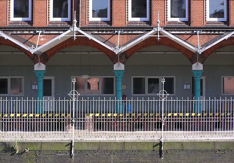 017_19001 Eisenzaun mit Dekorspitzen an der historischen Zollstation in der Hamburger Speicherstadt - das Gebude liegt am Zollkanal, im Vordergrund ist die Kaimauer des Fleets zu erkennen, der den Freihafen vom Hamburger Stadtgebiet trennte. www.christoph-bellin.de