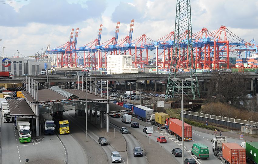 017_19023 Lastwagen, Containertransporter und PKW an der Zollstation Hamburg Waltershof - die LKW stauen sich an der Zollgrenze. Im Hintergrund die Conteinerkräne des Containerterminal am EUROKAI - einige Containerbrücken sind hoch geklappt. die Beladung oder Entladung des Containerschiffs ist abgeschlossen. Rechts ist die Arbeit noch in vollem Gange, die hochgestapelten Container an Deck des Frachters sind gut zu erkennen.    ©www.christoph-bellin.de