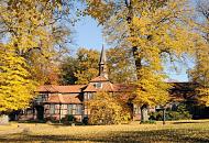 1609_1725 Die alten und hohen Linden vor dem Torhaus in Hamburg Wellingsbttel tragen gelb - goldene Herbstbltter. Die Wiese vor dem historischen Gebude ist mit abgefallenem Laub bedeckt.