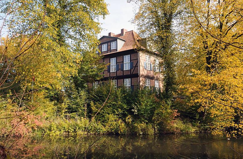 1771_9296 Historisches Herrenhaus im Hamburger Stadtteil Wohldorf Ohlstedt - das Fachwerk-Gebude wurde 1713 fertig gestellt. Bume und Strucher stehen am Ufer des Teichs; die ste mit Herbstlaub hngen dicht ber dem Wasser.