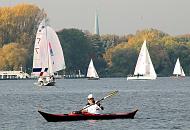 267_0367  Segelboote und Kanufahrer auf der Aussenalster in der Herbstsonne - die Bume am Alsterufer strahlen in herbstlichen Farben. Zwischen den Baumwipfeln der Kirchturm der St. Nikolaikirche am Klosterstern.