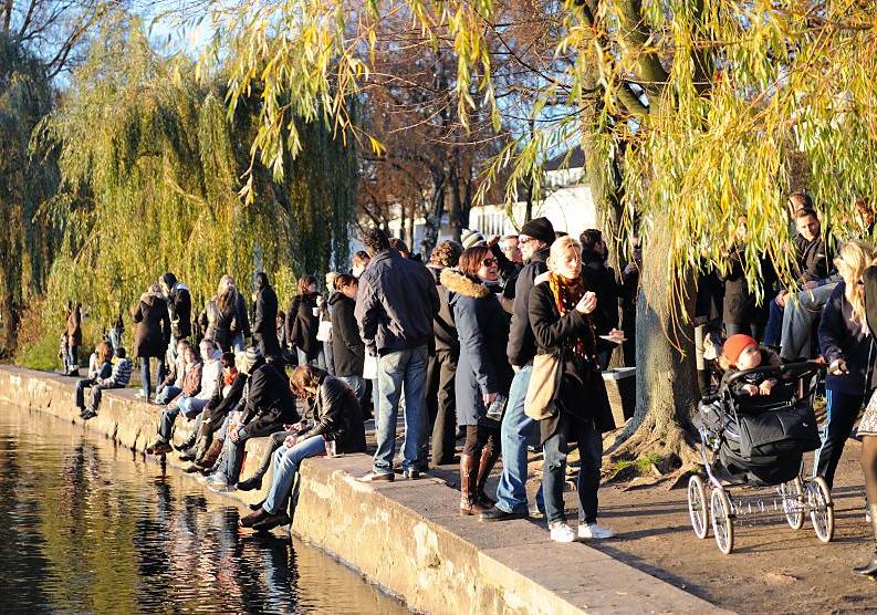 414_1376 Die Hamburger und Hamburgerinnen geniessen einen der schnen sonnigen Herbsttage am Ufer der Aussenalster - sie haben sich in der Alsterperle mit Getrnken und Kuchen versorgt und sitzen auf der Ufermauer in der Sonne und blicken auf die Alster. 