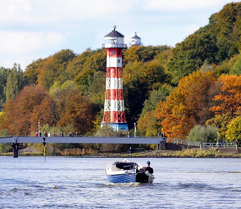 912_1730 Ein Tuckerboot fhrt auf der Elbe Hhe Leuchtfeuer Wittenbergen - auf der Wassertreppe, die zum Anleger fhrt stehen Spaziergnger und blicken auf die Elbe. Die Bume am bewaldeten Ufer tragen teilweise Herbstfrbung. 