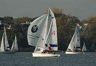 16_03825  vor der Kulisse der herbstlichen Bume am Alsterufer fhrt ein Segelschiff auf der Hamburger Aussenalster mit Spinnaker in voller Fahrt vor dem Wind - im Hintergrund weitere Segelboote, die an der wohl letzten Regatta der Hamburger Segelsaison auf der Alster teilnehmen.   www.christoph-bellin.de