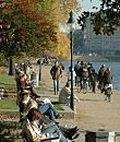 16_03818 Mittagsstunde in der Hamburger Innenstadt; die Hamburger und Hamburgerinnen sitzen in auf Parkbnken in der Sonne an der Binnenalster bei der Lombardsbrcke - Fahrradfahrer fahren auf dem Fussweg Richtung Aussenalster. Im Hintergrund Gebude am Ballindamm.   www.christoph-bellin.de