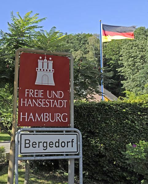 17_21460 Hamburgs sdstliche Stadtgrenze; ein rotes Schild mit weisser Schrift "Freie und Hansestadt Hamburg" weist auf die Grenze zum Stadtstaat Hamburg hin. Die Burg mit den Trmen und Zinnen ist das Wappen Hamburgs. Das weisse Schild darunter zeigt den Beginn des Hamburger Bezirks Bergedorf. www.hamburg-fotograf.com