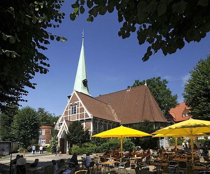 Bergedorfer Kirche St. Petri und Pauli - Strassencaf unter blauem Sommerhimmel.  Schon um 1162 wurde ein Kirchengebude am jetzigen Ort der Kirche im Zentrum des Stadtteils Bergedorf erwhnt. Die ursprngliche Kirche St. Petri und Pauli wurde 1502 eingeweiht und 1759 der jetzige Kirchturm errichtet. Rechts im Hintergrund das Pfarrhaus und links der Klinkerturm vom Hasse-Haus. Gste sitzen unter Sonnenschirmen im Caf auf dem Kirchplatz und geniessen das Sommerwetter mit strahlend blauem Himmel.