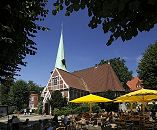 17_21478 Schon um 1162 wurde ein Kirchengebude am jetzigen Ort der Kirche im Zentrum des Stadtteils Bergedorf erwhnt. Die ursprngliche Kirche St. Petri und Pauli wurde 1502 eingeweiht und 1759 der jetzige Kirchturm errichtet. Rechts im Hintergrund das Pfarrhaus und links der Klinkerturm vom Hasse-Haus. Gste sitzen unter Sonnenschirmen im Caf auf dem Kirchplatz und geniessen das Sommerwetter mit strahlend blauem Himmel.www.hamburg-fotograf.com